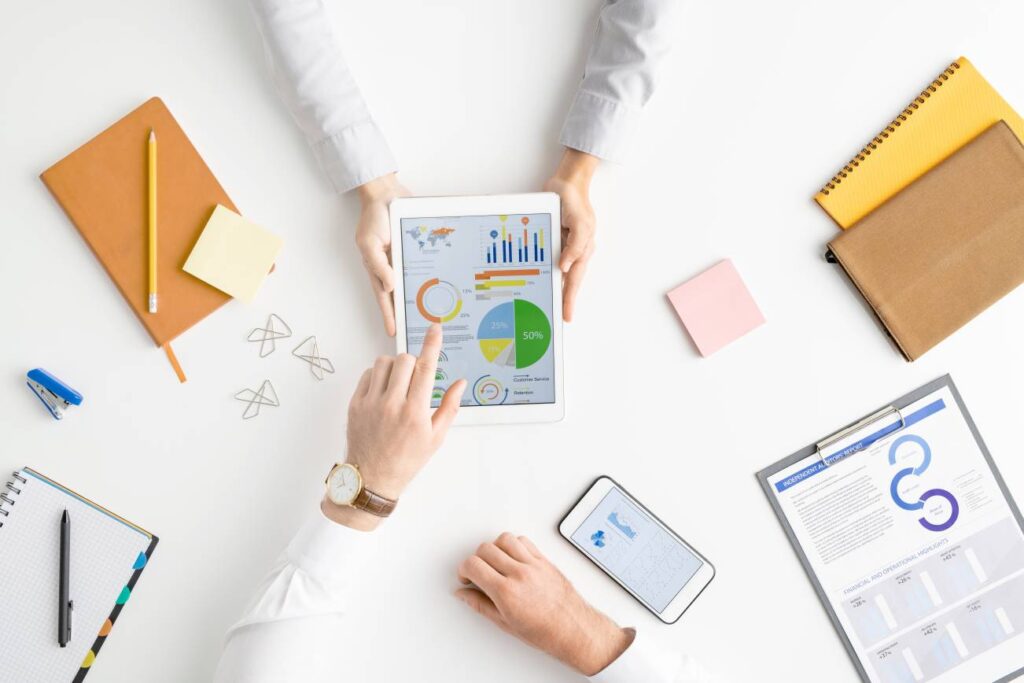 View of hands of two contemporary analysts or brokers discussing financial data